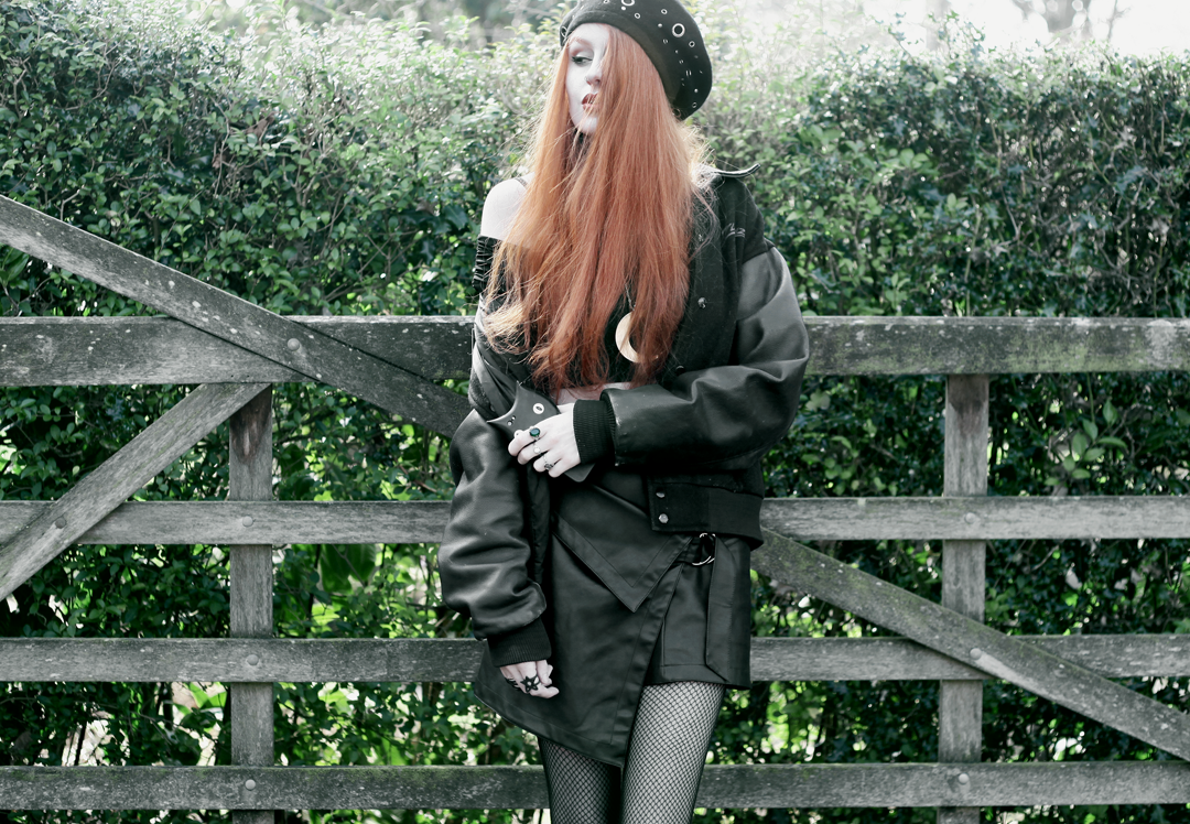 Olivia Emily wears Asos Eyelet beret, Killstar Luna Moon Necklace, Yayer high neck crop top under Asos Tall mesh off the shoulder wrap top, Vintage baseball jacket, asos faux leather wrap skirt & Underground triple sole creepers