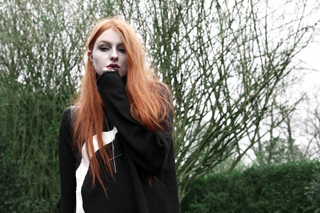 Olivia Emily wears Killstar oversized Luna moon sweater and Kiki Minchin silver Classic Cross necklace