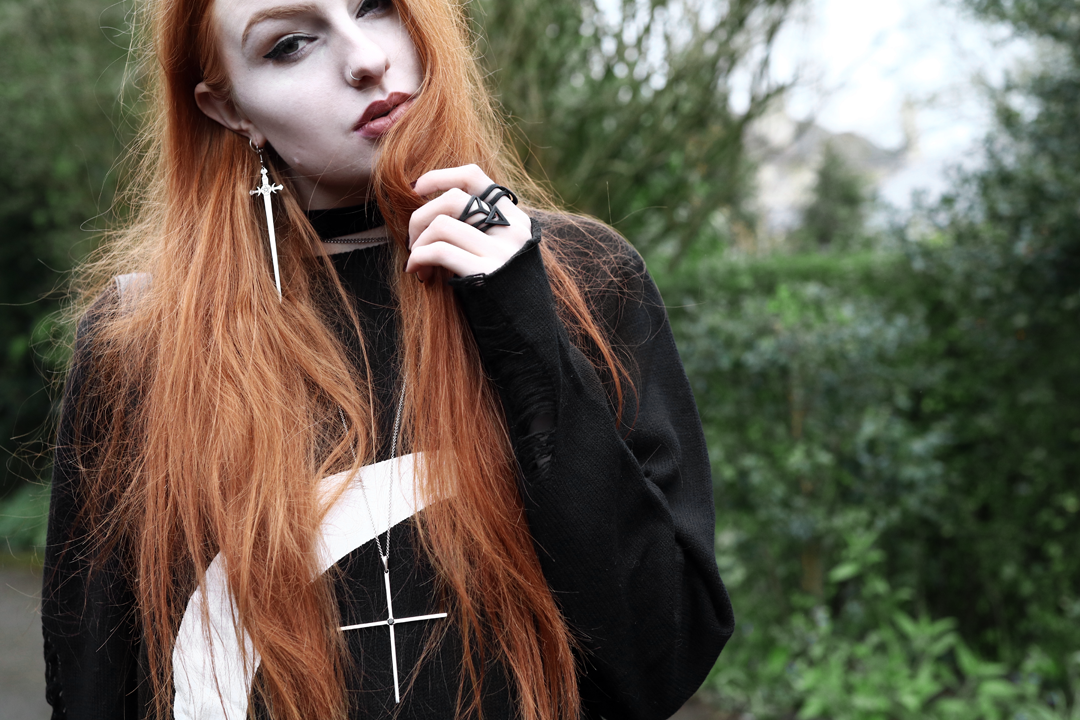 Olivia Emily wears Killstar oversized Luna moon sweater, Regalrose velvet choker, Killstar dagger earrings, The Rogue and The Wolf necklace and Kiki Minchin silver Classic Cross necklace