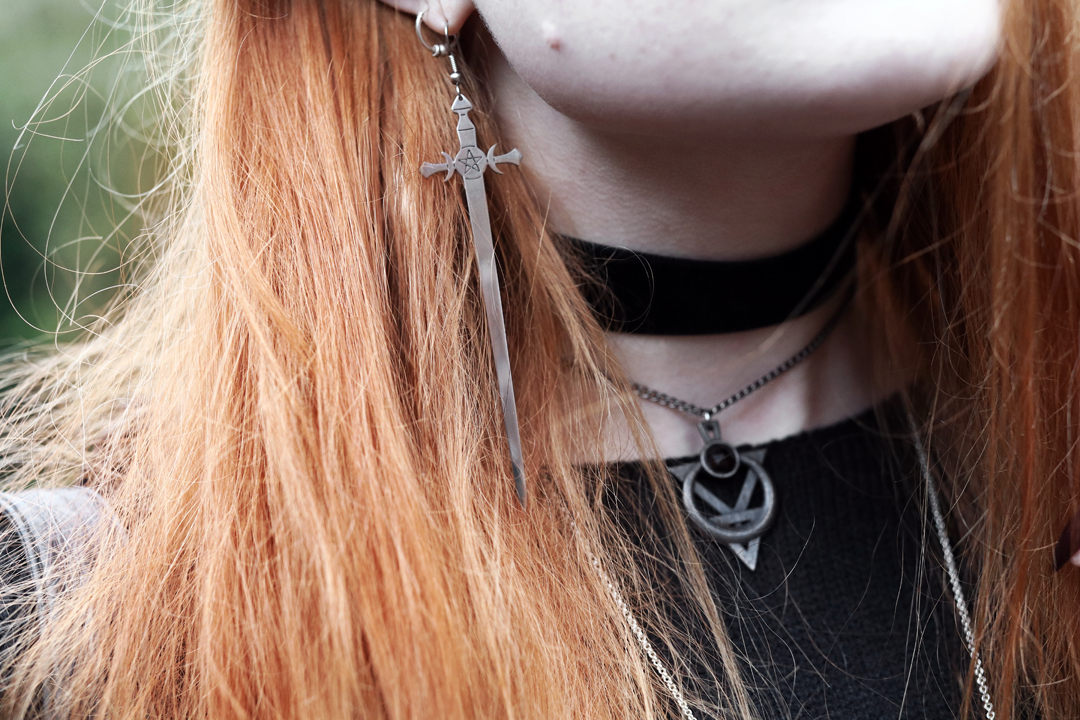 Olivia Emily wears Killstar oversized Luna moon sweater, Regalrose velvet choker, Killstar dagger earrings, The Rogue and The Wolf necklace