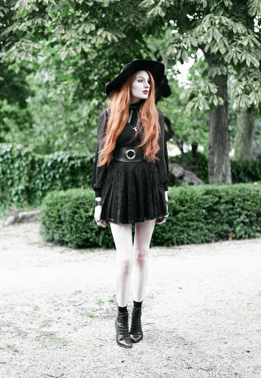 Olivia Emily wears Asos Sheer Shirt, Black Milk Black Lace Skater Dress, Killstar Velvet Witch Brim Hat, Valfre Bowie Choker, Zana Bayne Cincher Waist Belt, and Asos Ariana Lace Up Boots