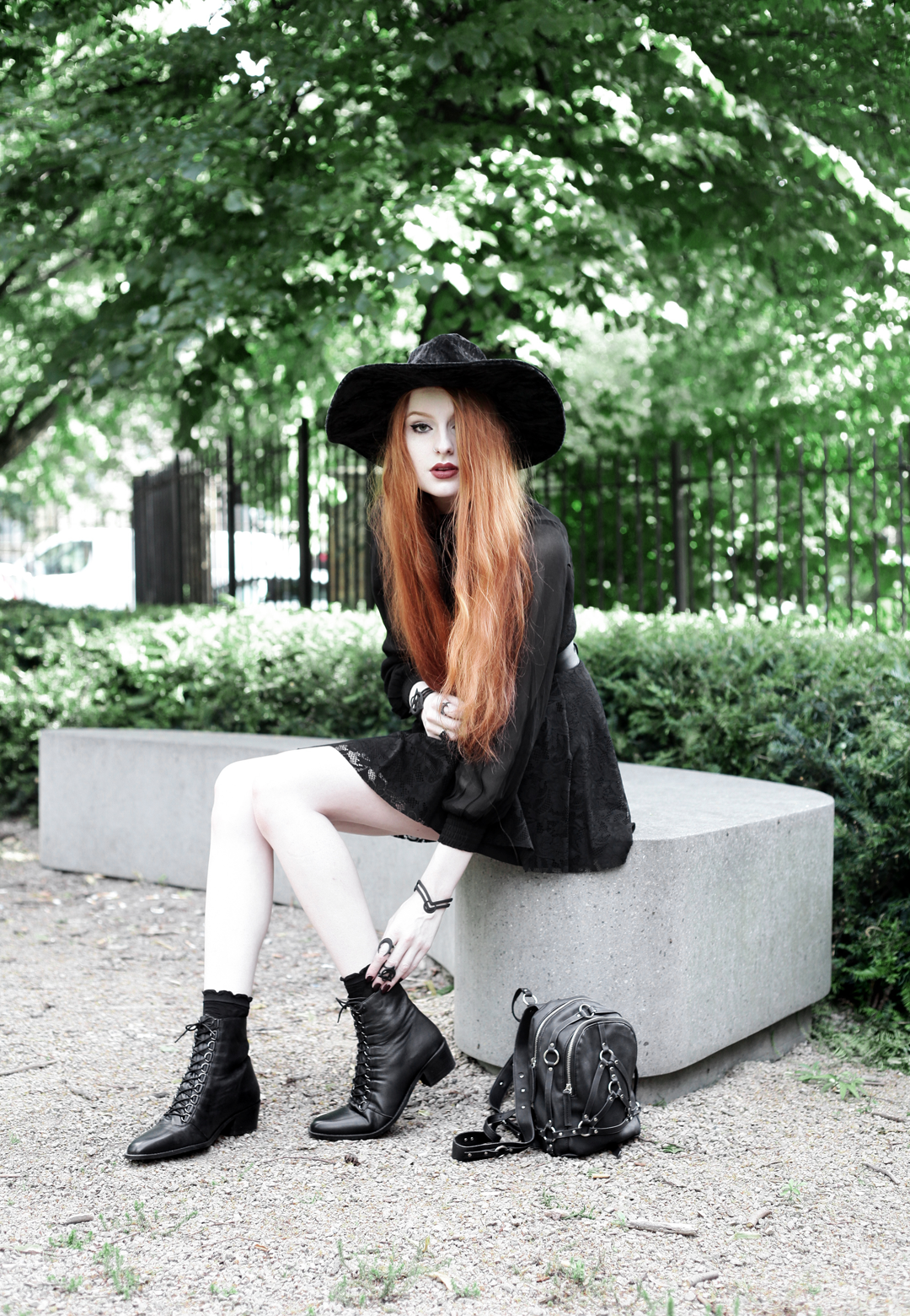 Olivia Emily wears Asos Sheer Shirt, Black Milk Black Lace Skater Dress, Killstar Velvet Witch Brim Hat, Zana Bayne Cincher Waist Belt, Unif Bound Mini Backpack and Asos Ariana Lace Up Boots