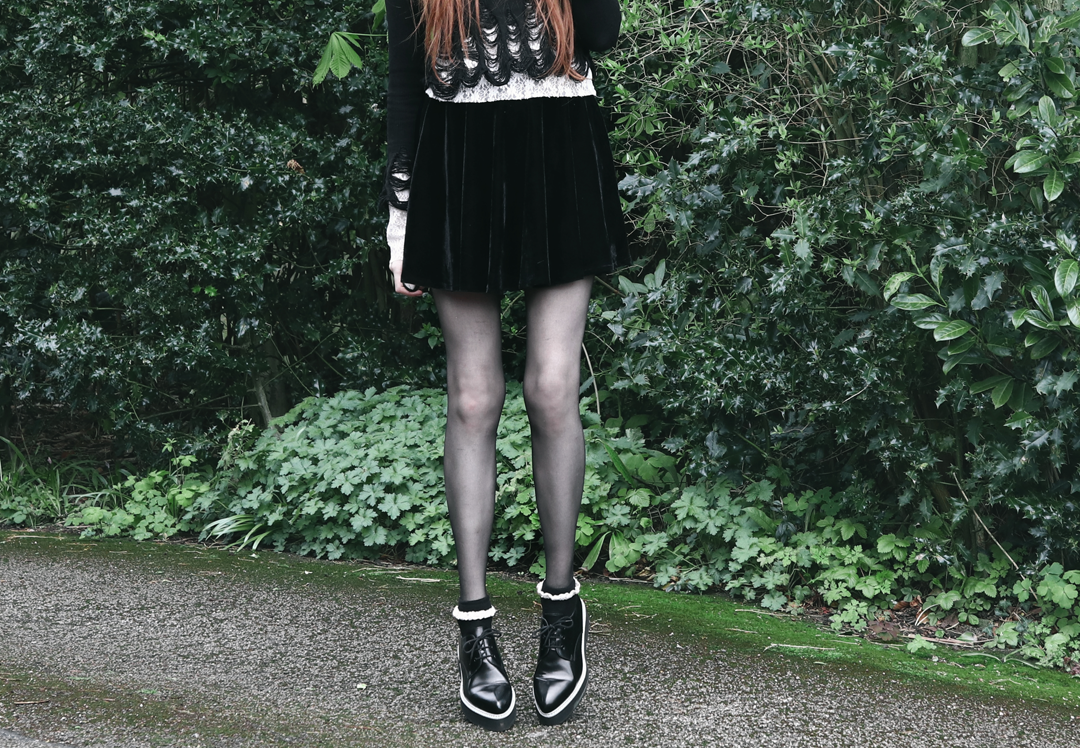 Olivia Emily wears Killstar Lestat shredded knit crop sweater, Black Velvet Skirt, Alexander McQueen platform shoes