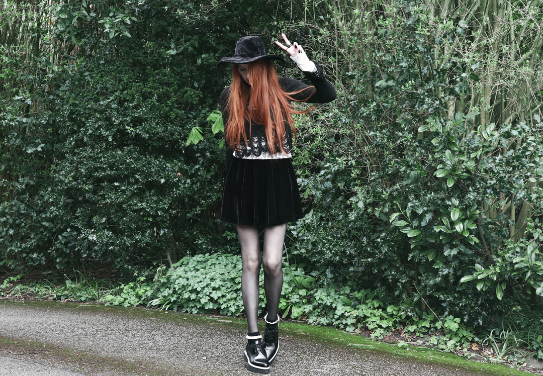 Olivia Emily wears Killstar Lestat shredded knit crop sweater, Killstar Velvet Witch Brim Hat, Black Velvet Skirt, Alexander McQueen platform shoes