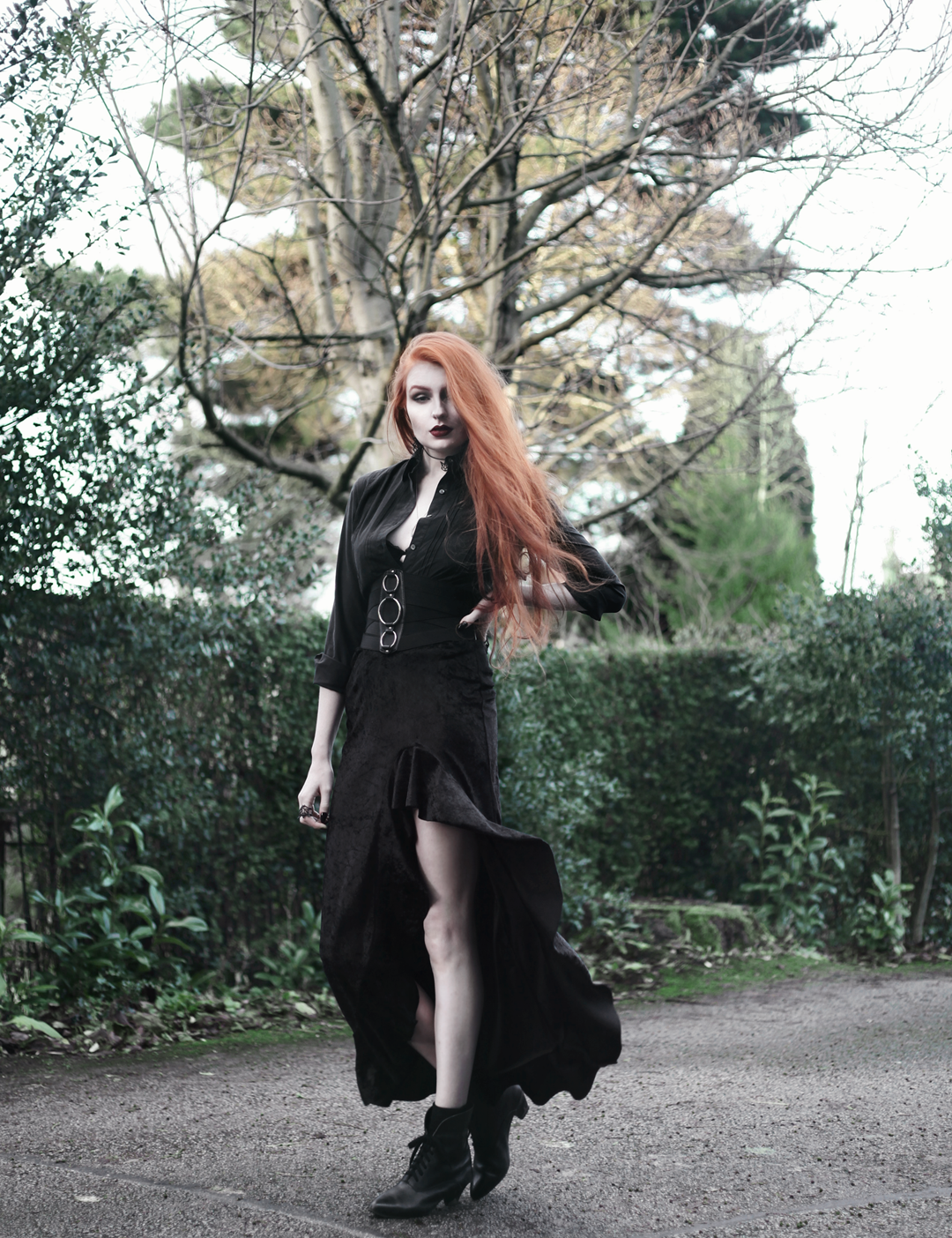 Olivia Emily wears Black Shirt, Asos Triple Ring Belt, Rokoko Velvet Ruffle High Low Maxi Skirt, and Vintage Pointed Boots