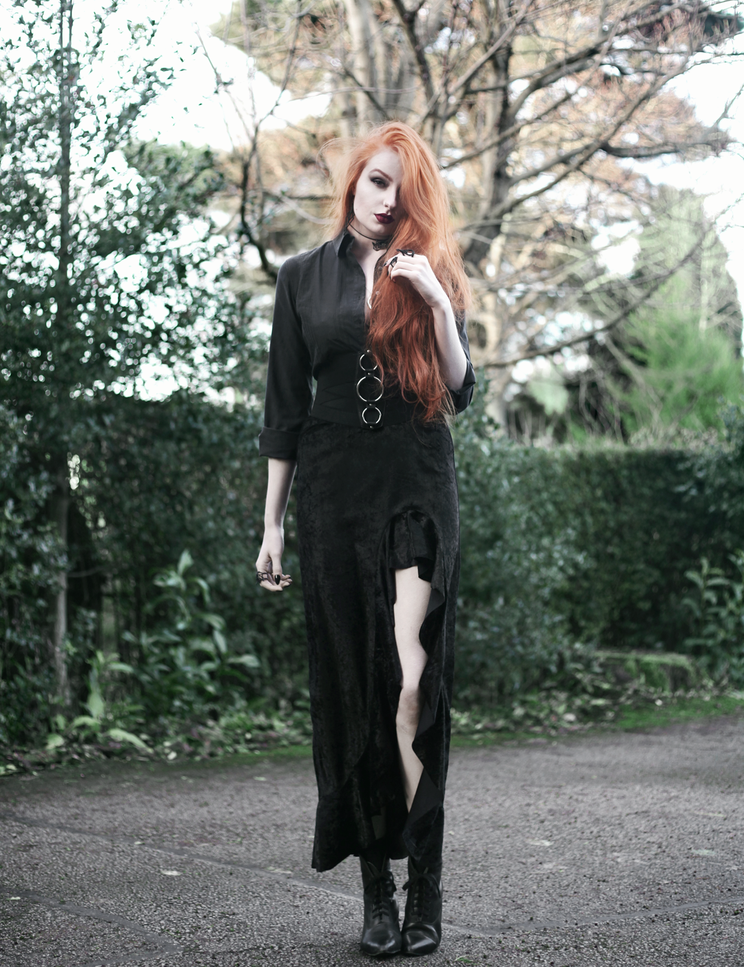 Olivia Emily wears Black Shirt, Asos Triple Ring Belt, Rokoko Velvet High Low Ruffle Skirt, and Vintage Pointed Boots