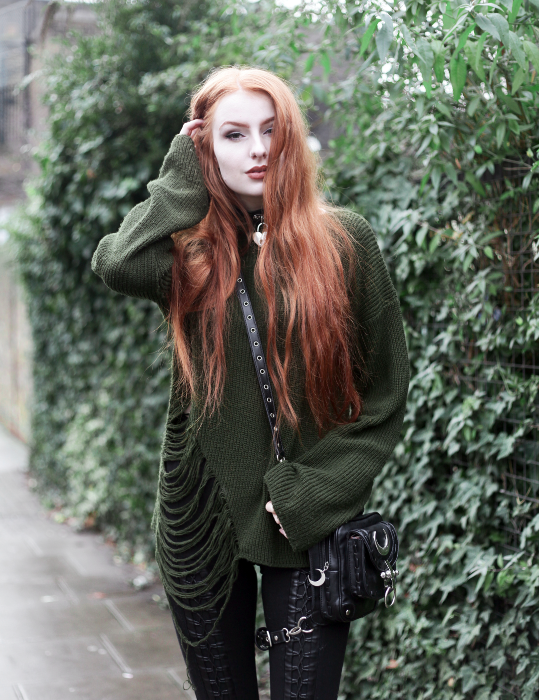 Olivia Emily wears Asos Bones Oversized jumper, Restyle pl harness bag, Stylestalker lace up leggings trousers, and Killstar Emily Padlock choker collar