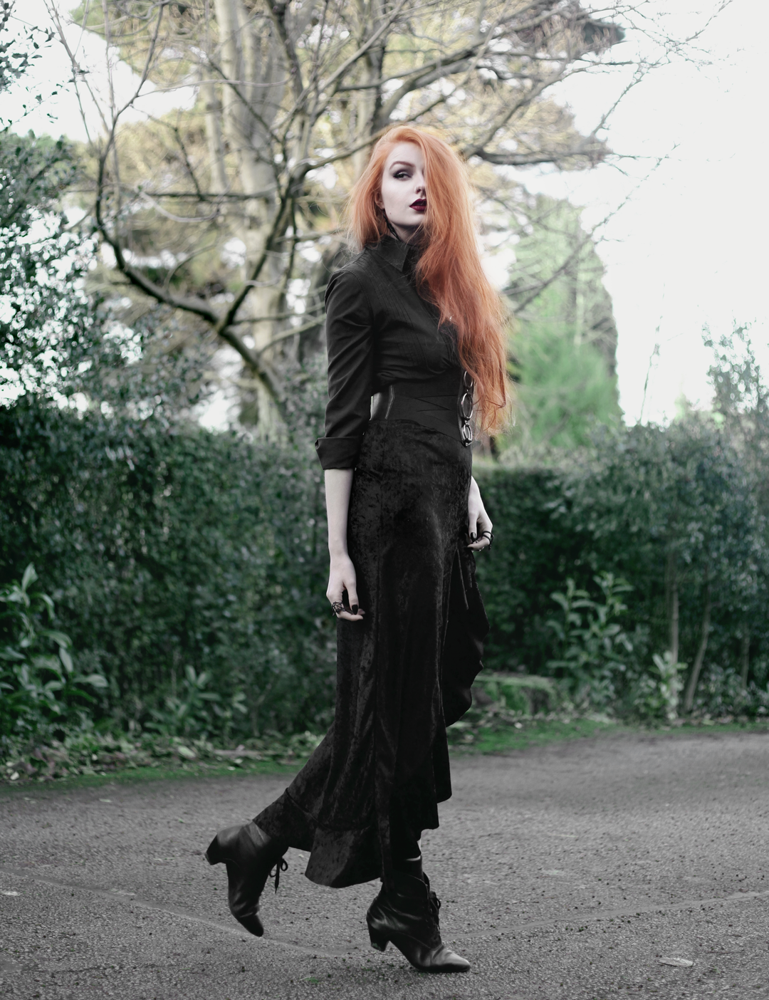 Olivia Emily wears Black Shirt, Asos Triple Ring Belt, Rokoko Velvet High Low Ruffle Skirt, and Vintage Pointed Boots