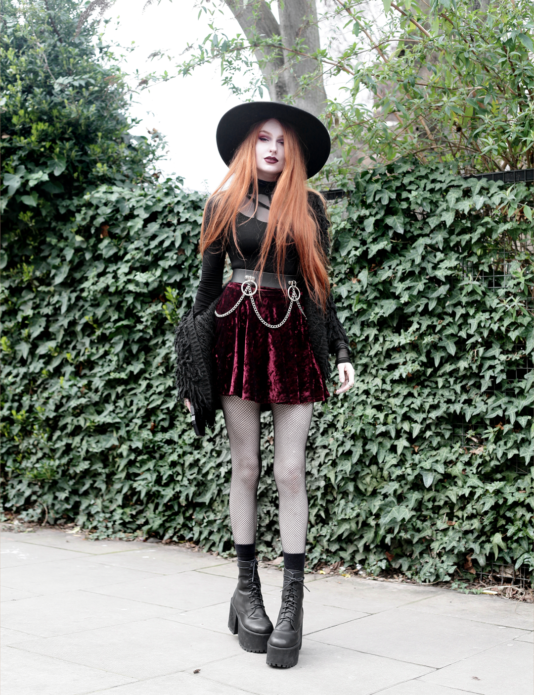 Olivia Emily wears Rogue and Wolf Moondoll Top, Killstar Fedora Hat, Crushed Velvet skirt, Mary Wyatt Chain Belt and Unif Scosche Boots