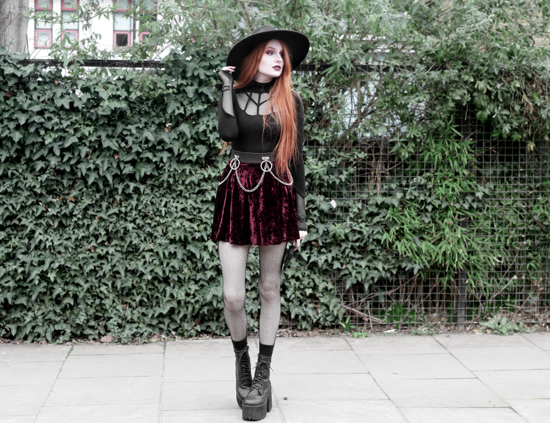 Olivia Emily wears Rogue and Wolf Moondoll Top, Killstar Fedora Hat, Crushed Velvet skirt, Mary Wyatt Chain Belt and Unif Scosche Boots