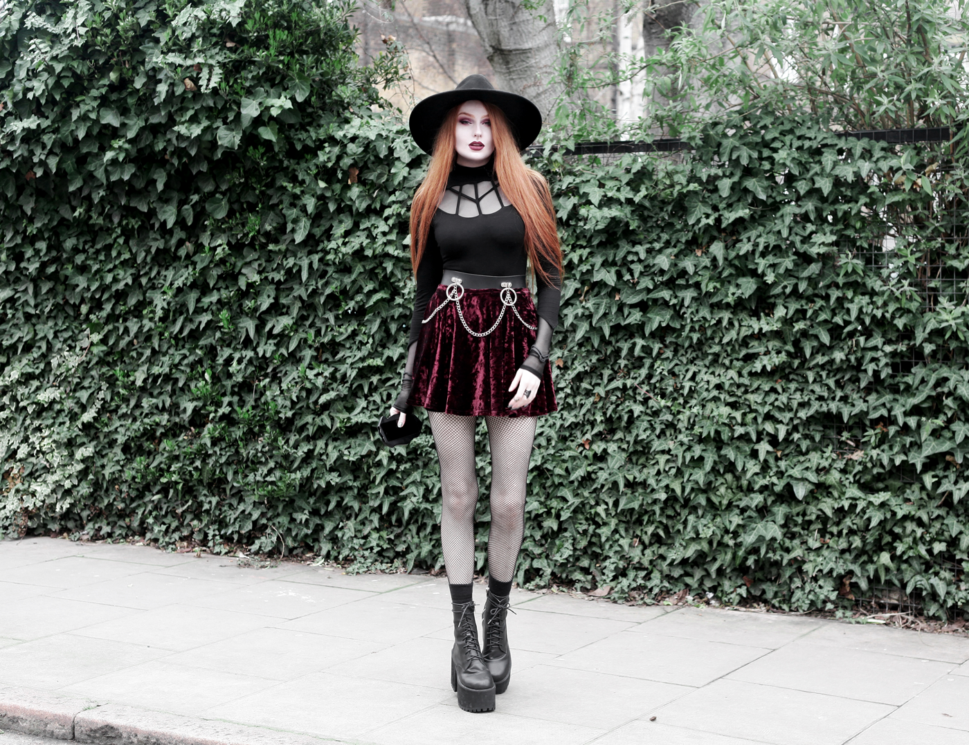 Olivia Emily wears Rogue and Wolf Moondoll Top, Killstar Fedora Hat, Crushed Velvet skirt, Mary Wyatt Chain Belt and Unif Scosche Boots