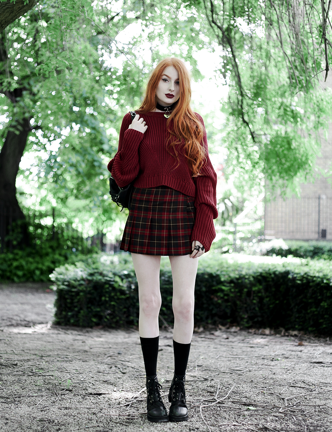 Olivia Emily wears River Island Studio Red Jumper, Topshop red plaid check skirt, Killstar Heart Choker, and Unif Dedi Boots