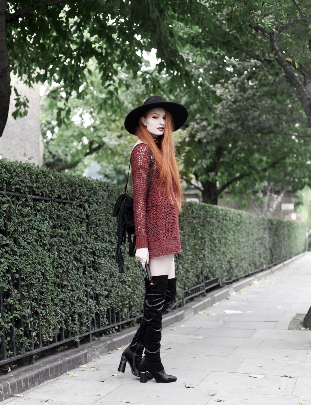 Olivia Emily wears Unif Knit Jumper, Asos Fringe Backpack, Killstar Witch Brim Hat, and Ego Velvet Over Knee Boots