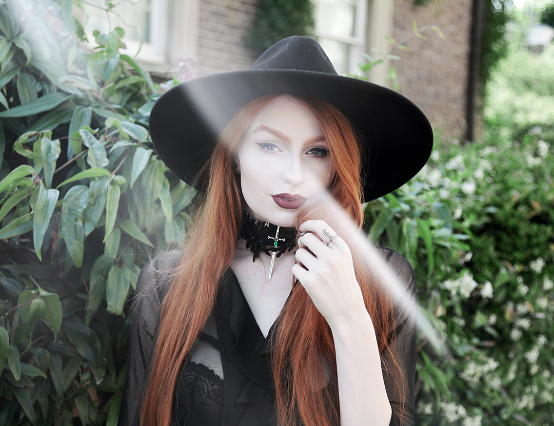 Olivia Emily wears Killstar Witch Brim Hat, Killstar Decay Nu-Mourning dress, and  Pheren Couture Sword Choker