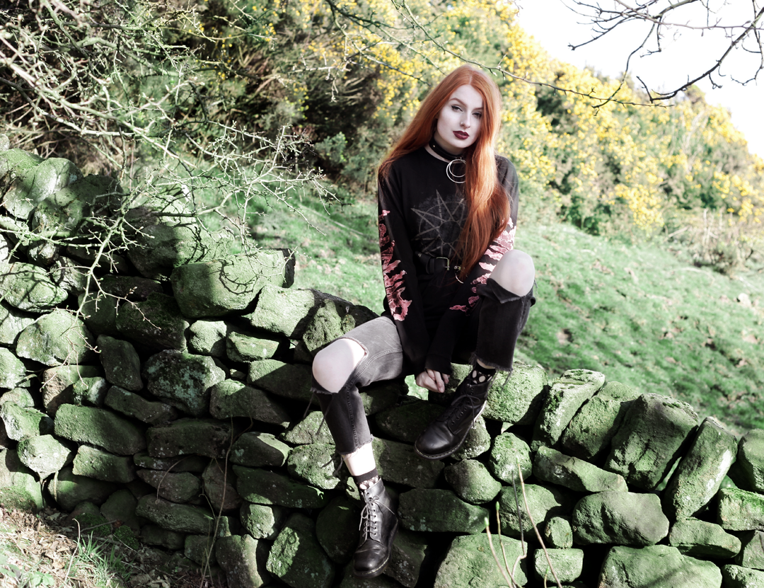 Olivia Emily wears Slipknot Band Tee, Asos ripped straight leg jeans, pothole fishnet socks, and Dr Martens boots